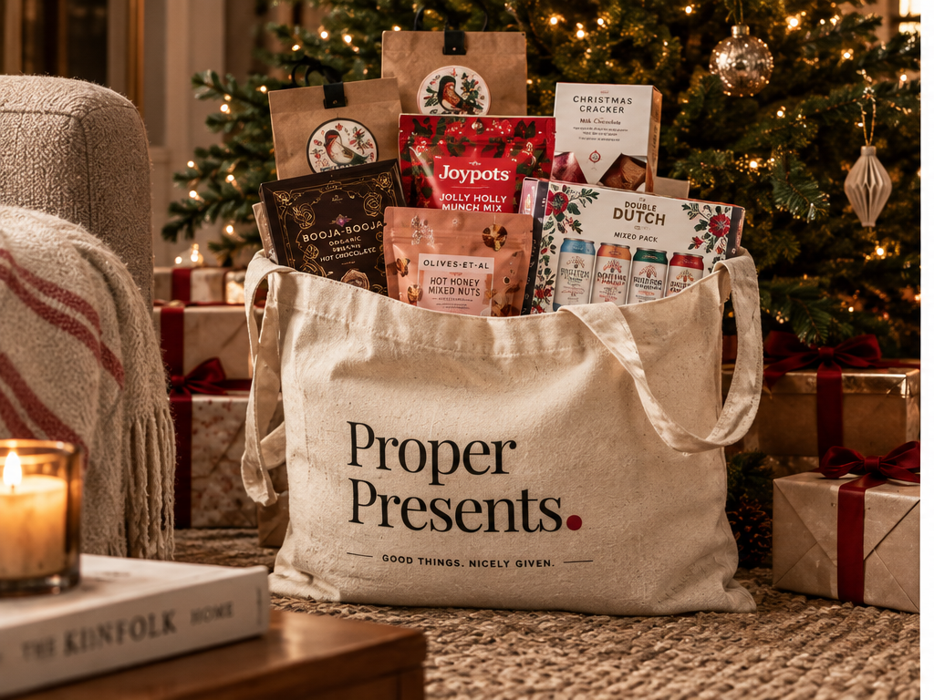 Proper Presents tote bag filled with gifts beneath a Christmas tree
